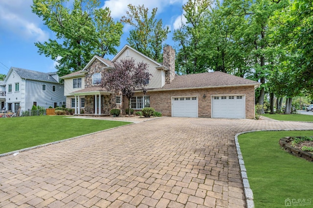 view of front of property featuring a garage, a chimney, decorative driveway, a front lawn, and brick siding