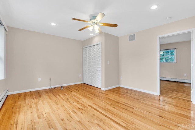 unfurnished bedroom featuring light wood-type flooring, baseboards, visible vents, and baseboard heating