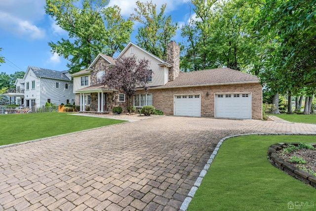 view of front of property featuring a garage, brick siding, decorative driveway, a chimney, and a front yard