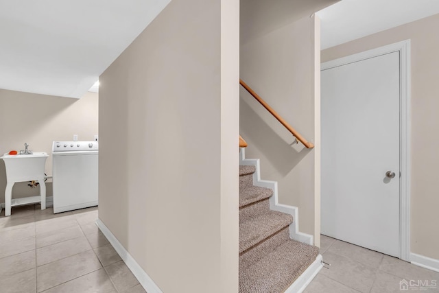 stairs with washer / clothes dryer, baseboards, and tile patterned floors