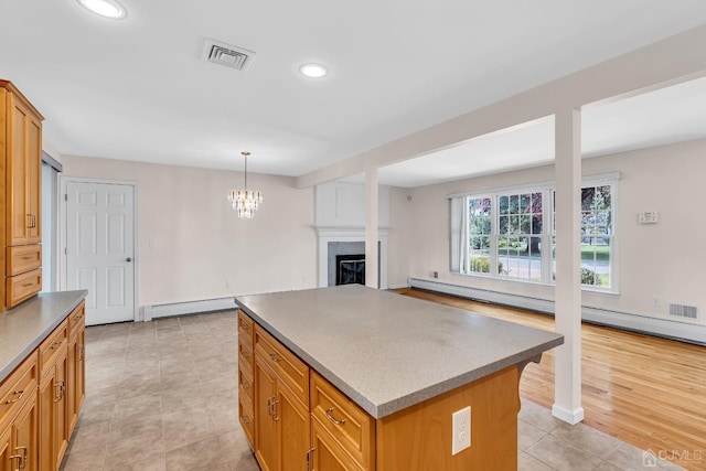 kitchen with recessed lighting, a fireplace, a kitchen island, visible vents, and baseboard heating