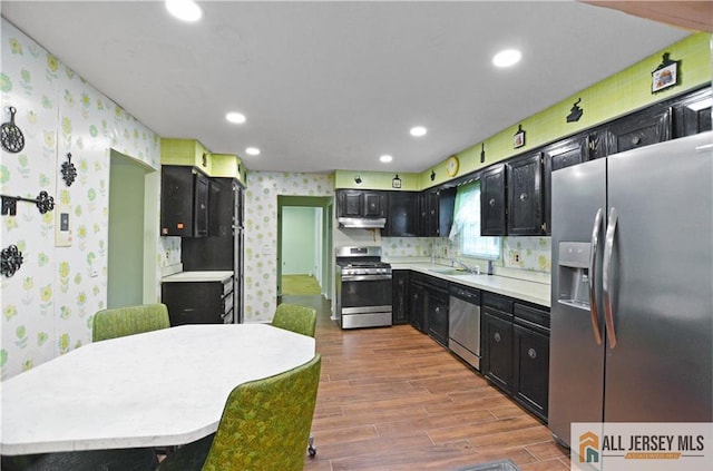 20 Rath Ln, East Brunswick, NJ 08816 - kitchen with appliances with stainless steel finishes, wallpapered walls, dark cabinetry, dark wood-style floors, and light countertops