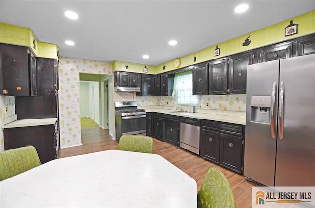 20 Rath Ln, East Brunswick, NJ 08816 - kitchen with appliances with stainless steel finishes, under cabinet range hood, light countertops, wood finished floors, and recessed lighting