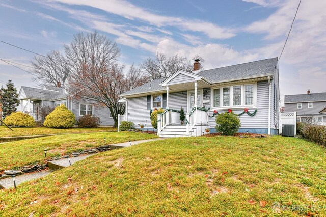 view of front of house featuring a front lawn and central AC unit