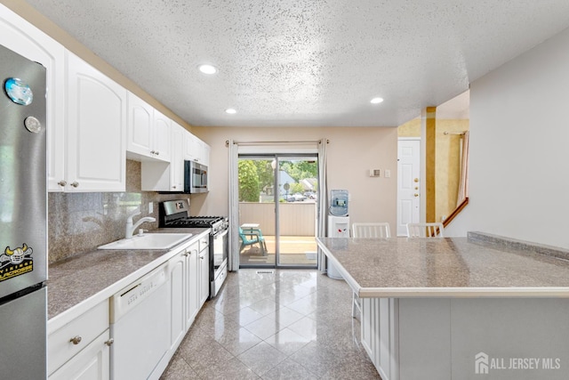 12 Arbor Ct, South Brunswick, NJ 08852 - kitchen with stainless steel appliances, recessed lighting, granite floors, a textured ceiling, and white cabinets