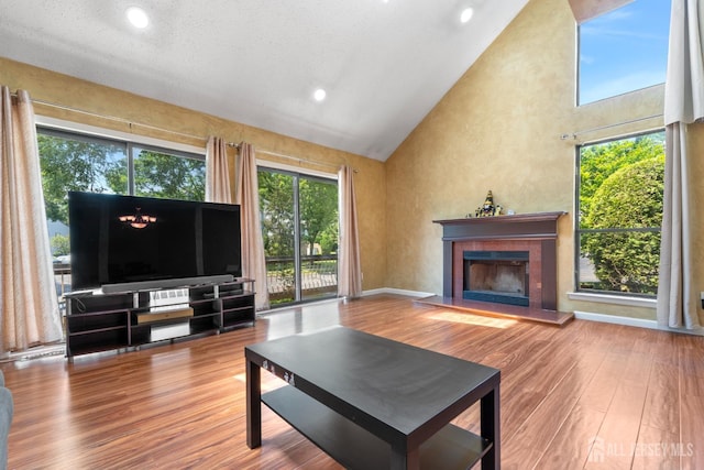 12 Arbor Ct, South Brunswick, NJ 08852 - living area featuring high vaulted ceiling, a tiled fireplace, plenty of natural light, wood finished floors, and recessed lighting