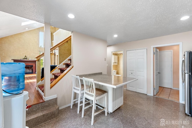 12 Arbor Ct, South Brunswick, NJ 08852 - kitchen with freestanding refrigerator, a kitchen breakfast bar, a textured ceiling, recessed lighting, and a peninsula