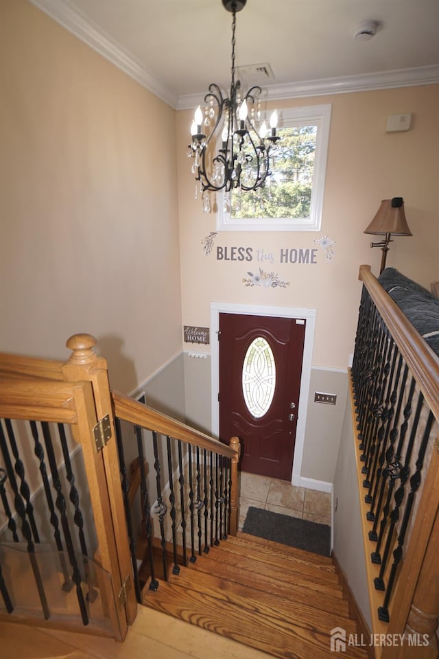 foyer featuring stairway, baseboards, an inviting chandelier, and crown molding