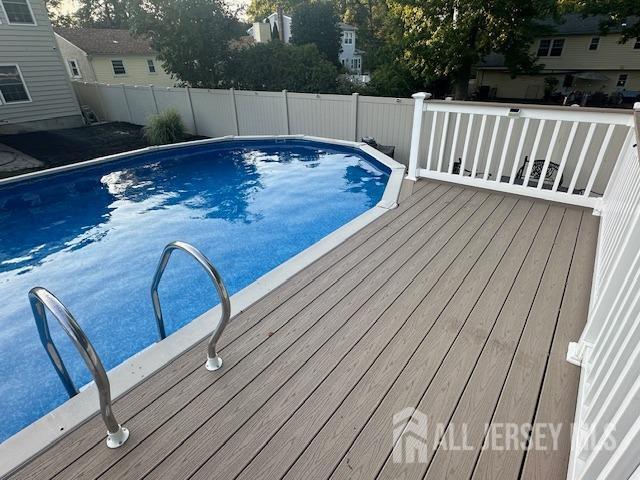 view of pool featuring fence and a wooden deck