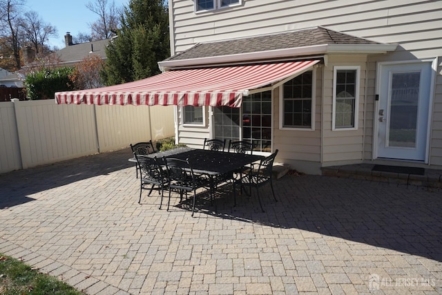 view of patio featuring outdoor dining space and fence