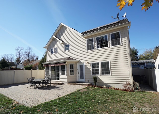 rear view of house with a patio, a yard, and a fenced backyard