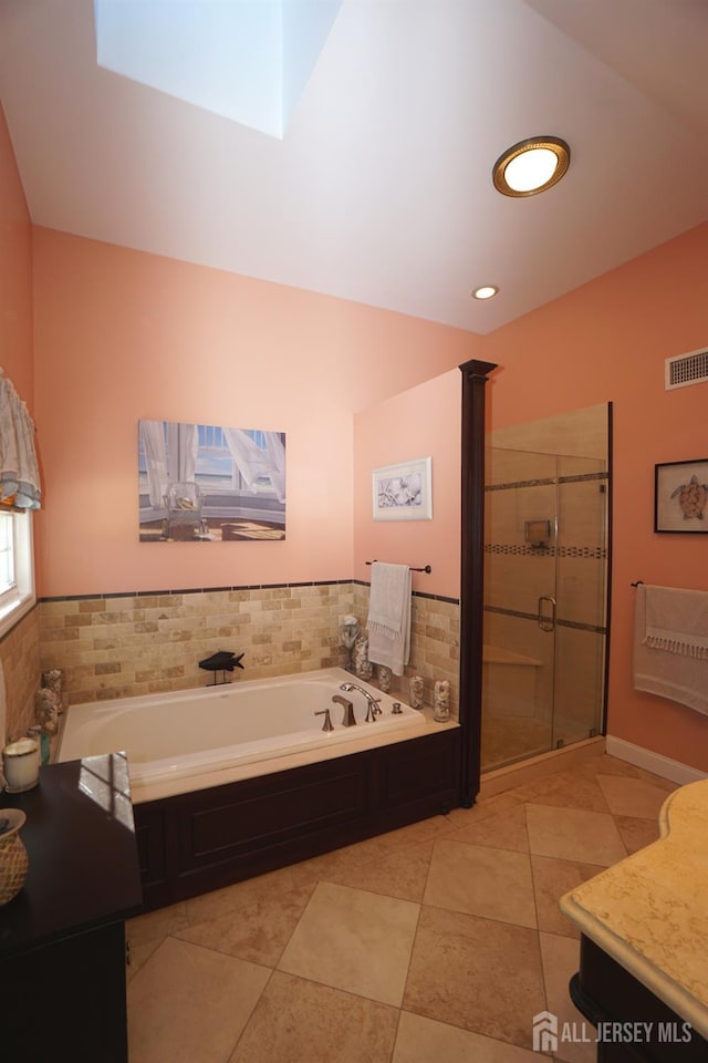 bathroom featuring visible vents, a skylight, a stall shower, tile patterned floors, and a bath