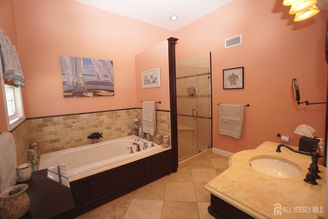 bathroom featuring tile patterned flooring, visible vents, a shower stall, a bath, and vanity