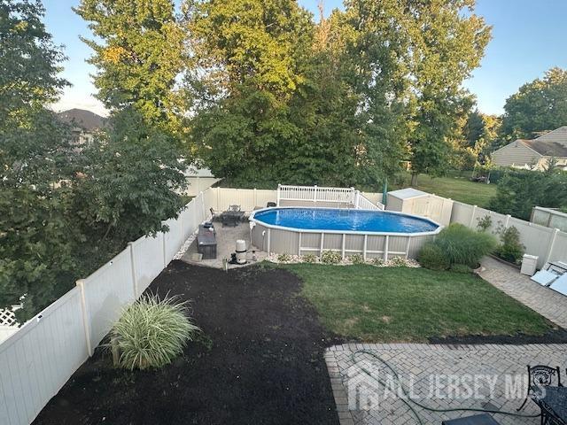 view of pool with a fenced backyard, a fenced in pool, and a yard