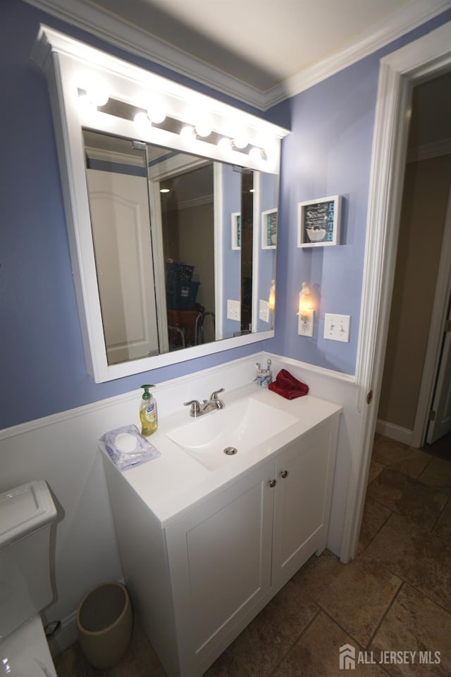 bathroom with vanity, toilet, and ornamental molding