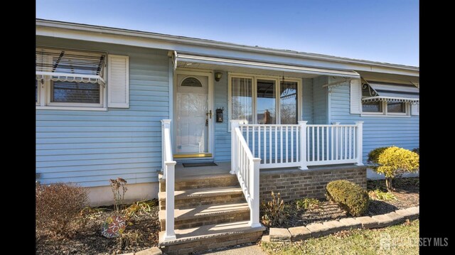 view of exterior entry with a porch