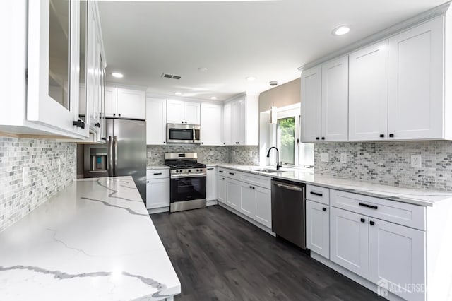 15 Pennyroyal Ct, South Brunswick, NJ 08540 - kitchen with appliances with stainless steel finishes, a sink, white cabinetry, backsplash, and light stone counters