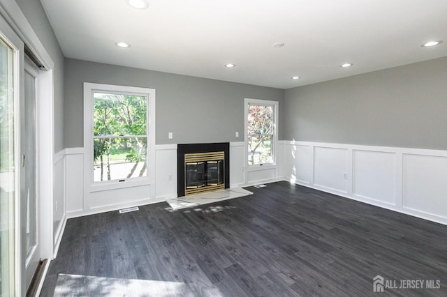 15 Pennyroyal Ct, South Brunswick, NJ 08540 - unfurnished living room with a wainscoted wall, a decorative wall, a glass covered fireplace, dark wood-style flooring, and recessed lighting