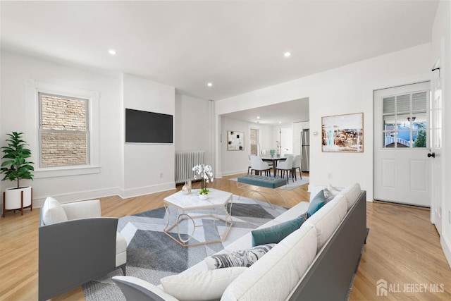 living room featuring radiator heating unit and light hardwood / wood-style floors