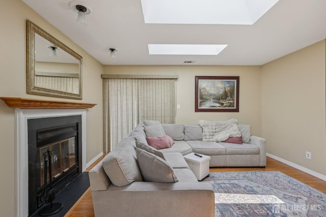 6 E Wintergreen Ave, Edison, NJ 08820 - living area with a glass covered fireplace, wood finished floors, and a skylight