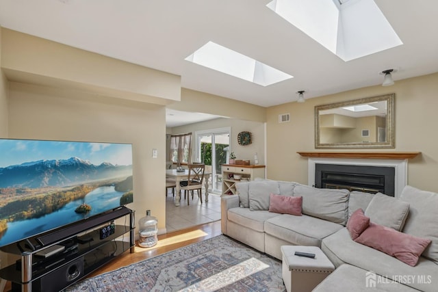 6 E Wintergreen Ave, Edison, NJ 08820 - living room featuring a skylight, a glass covered fireplace, and wood finished floors