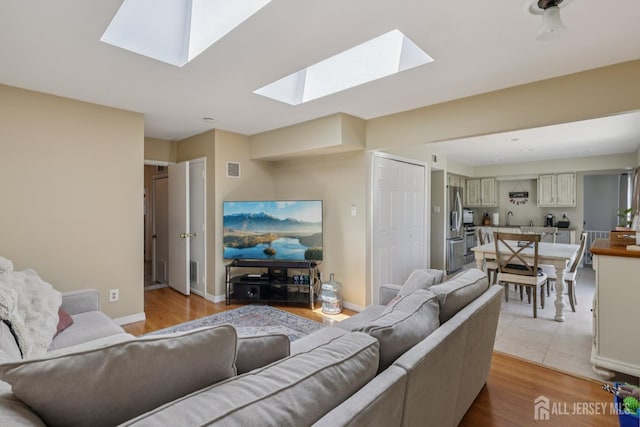 6 E Wintergreen Ave, Edison, NJ 08820 - living room featuring a skylight and light wood-style floors