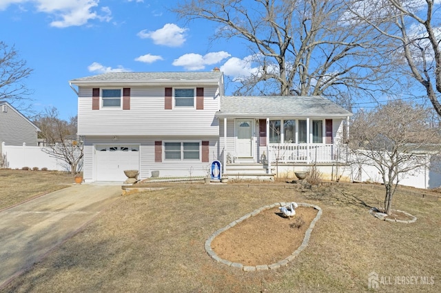 tri-level home with driveway, fence, covered porch, a shingled roof, and a garage