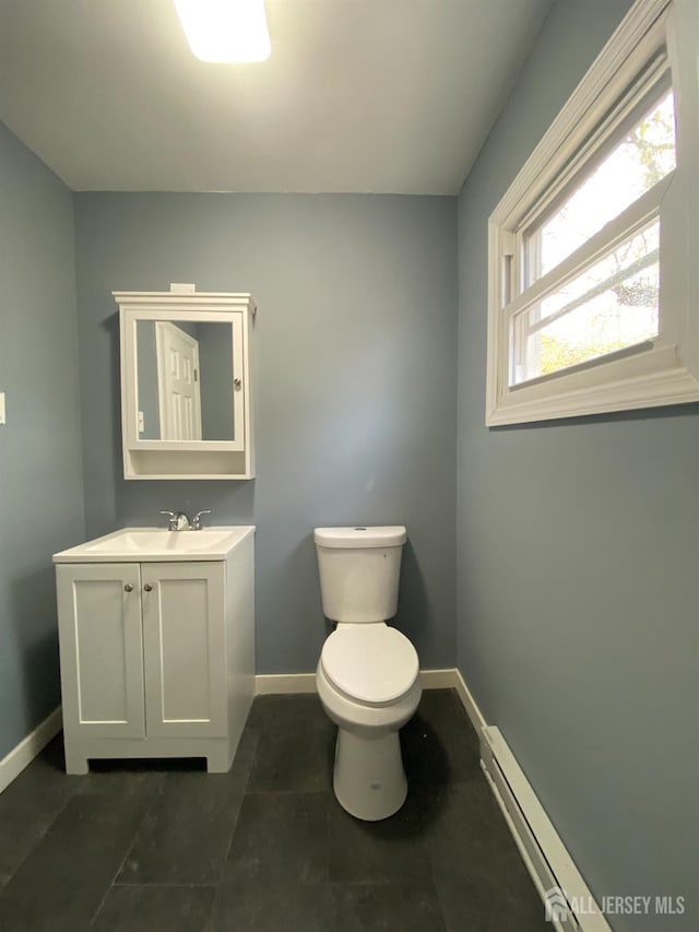 bathroom featuring vanity, baseboard heating, and toilet