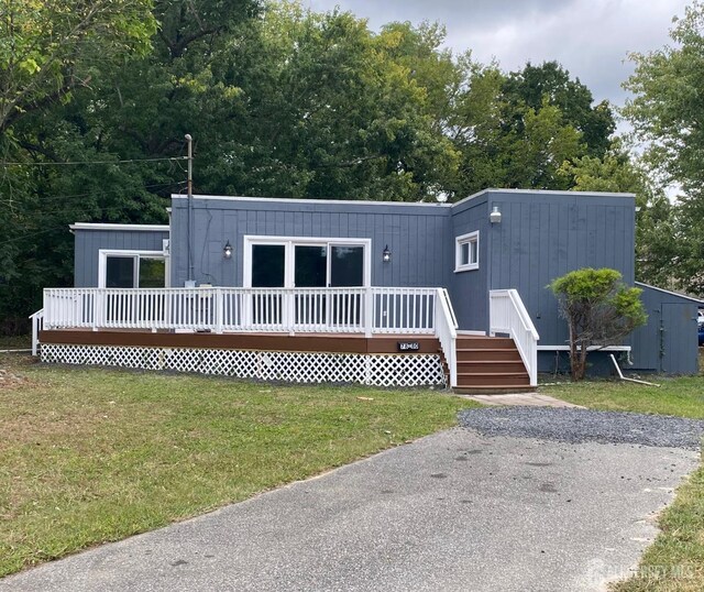 exterior space with a wooden deck and a lawn