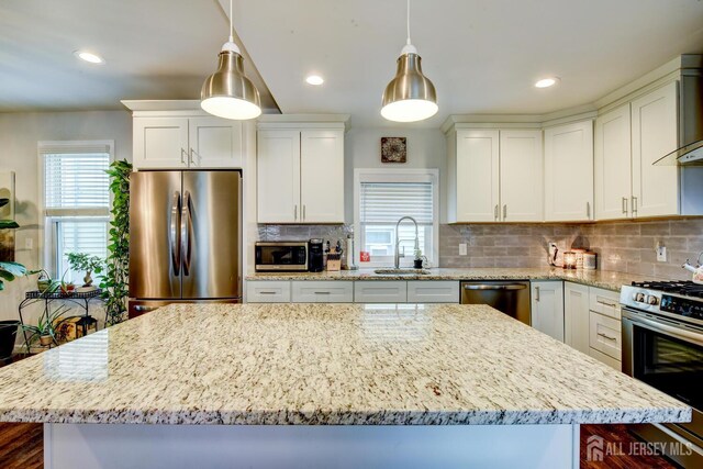 382 Highland St, South Amboy, NJ 08879 - kitchen featuring stainless steel appliances, a kitchen island, light stone counters, tasteful backsplash, and recessed lighting
