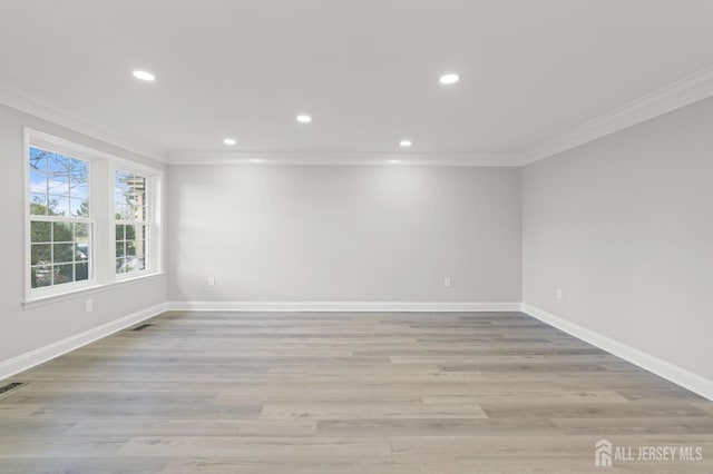 empty room featuring light wood-type flooring and ornamental molding