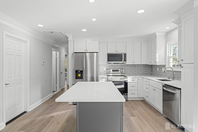 kitchen with white cabinetry, a center island, stainless steel appliances, and sink