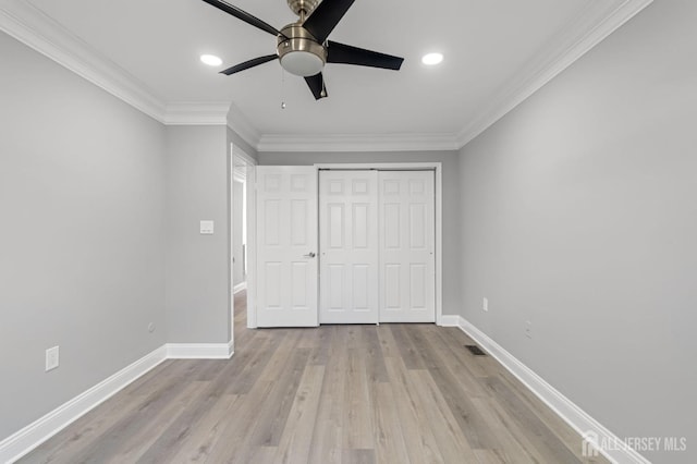 unfurnished bedroom with ceiling fan, a closet, crown molding, and light wood-type flooring