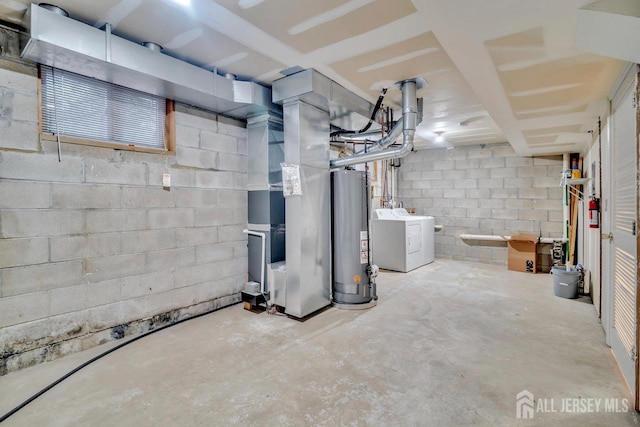 unfinished basement featuring heating unit, water heater, concrete block wall, and washing machine and dryer