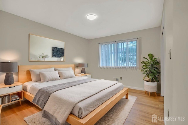 bedroom with baseboards and light wood-style flooring