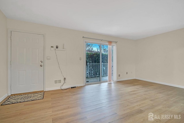 interior space with baseboards, visible vents, and light wood finished floors