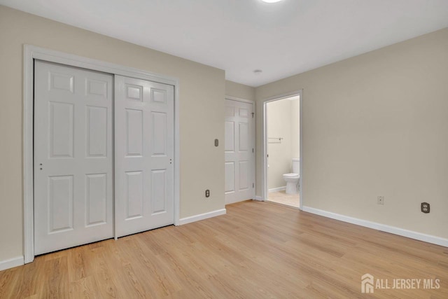 unfurnished bedroom featuring baseboards, connected bathroom, and light wood finished floors