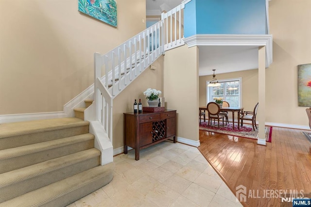 87 Fairway Blvd, Middlesex, NJ 08831 - staircase featuring baseboards, a chandelier, and a towering ceiling