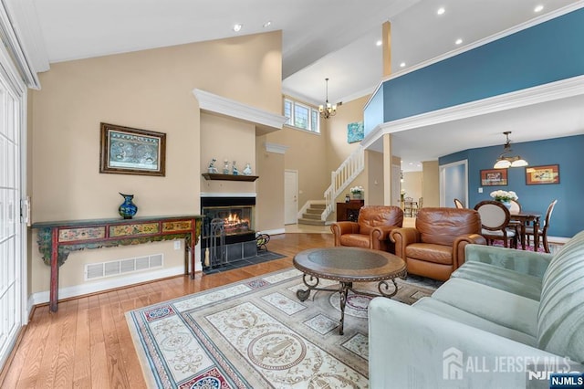 87 Fairway Blvd, Middlesex, NJ 08831 - living area with a chandelier, stairway, wood finished floors, a fireplace with flush hearth, and a towering ceiling