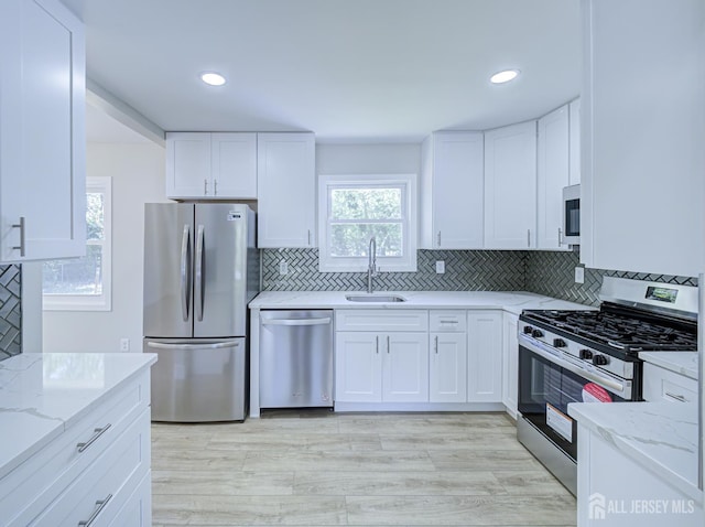 44 Sullivan Way E, Brunswick, NJ 08816 - kitchen featuring appliances with stainless steel finishes, a sink, light stone counters, healthy amount of natural light, and recessed lighting