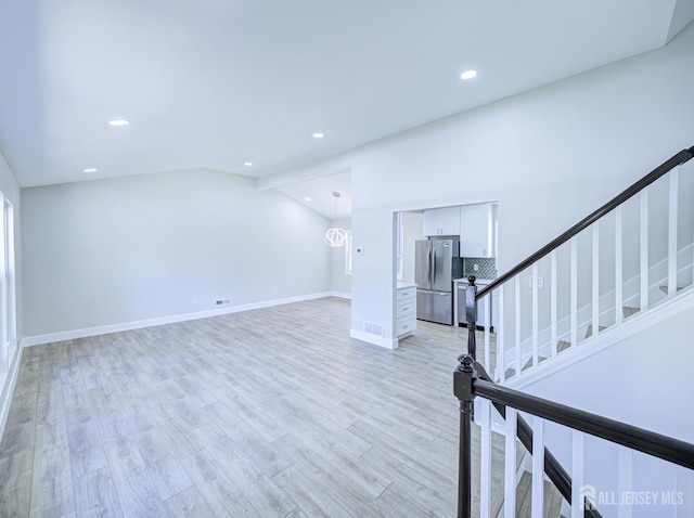 44 Sullivan Way E, Brunswick, NJ 08816 - unfurnished living room with light wood finished floors, recessed lighting, stairway, lofted ceiling, and baseboards