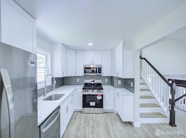 44 Sullivan Way E, Brunswick, NJ 08816 - kitchen with stainless steel appliances, a sink, light stone counters, light wood-style flooring, and recessed lighting
