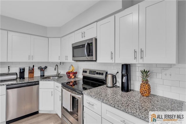 52 Lantern Ln, Sayreville, NJ 08872 - kitchen with appliances with stainless steel finishes, light stone counters, and white cabinets