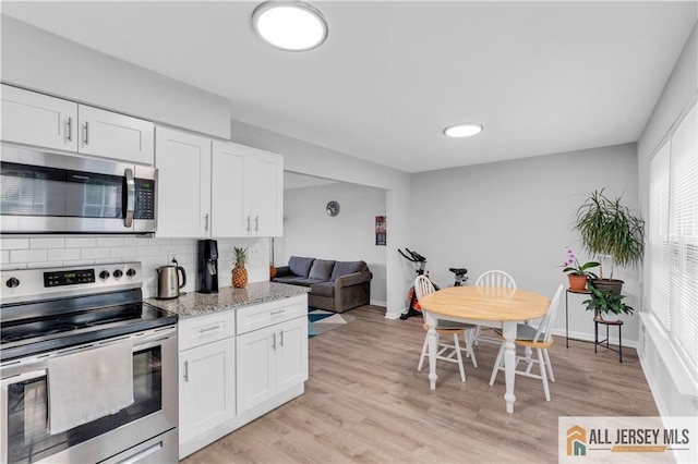 52 Lantern Ln, Sayreville, NJ 08872 - kitchen featuring appliances with stainless steel finishes, white cabinets, backsplash, and light stone countertops