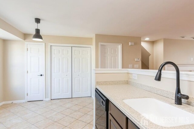 kitchen with pendant lighting, black dishwasher, light tile patterned flooring, and sink