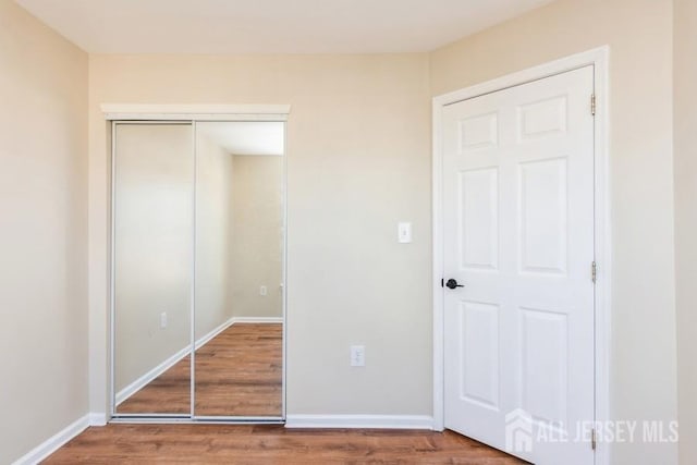 unfurnished bedroom with a closet and wood-type flooring