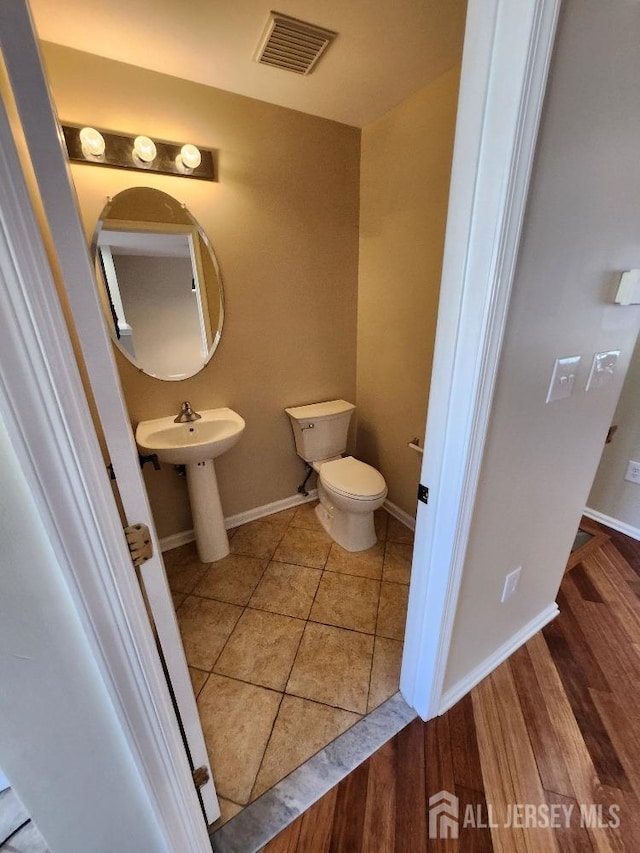 bathroom featuring hardwood / wood-style floors and toilet