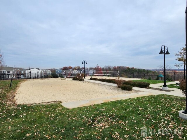 view of community featuring volleyball court and a lawn