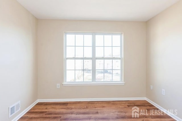 unfurnished room featuring hardwood / wood-style floors and a healthy amount of sunlight