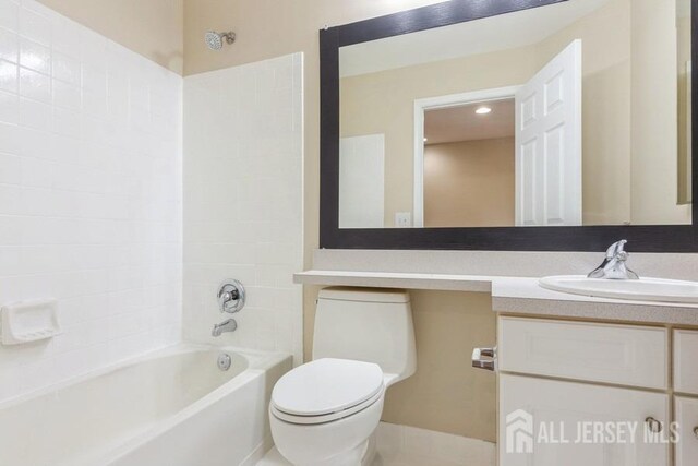 full bathroom featuring vanity, bathing tub / shower combination, and toilet